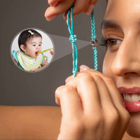 Thumbnail for Blue Photo Bracelet by Brother & Sisters showcasing a woman holding a personalized pendant with a baby photo.