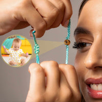 Thumbnail for Woman adjusting the Blue Photo Bracelet with a child playing in the background, showcasing personalization by Brother & Sisters.