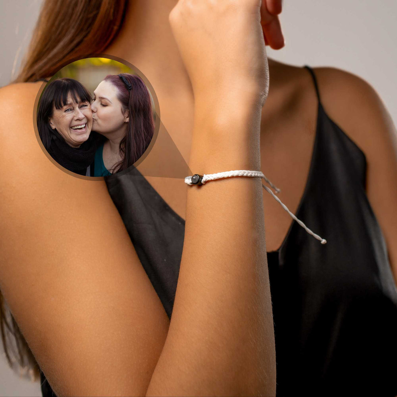 White Photo Bracelet featuring a personalized photo pendant from Brother & Sisters worn on a woman's wrist.