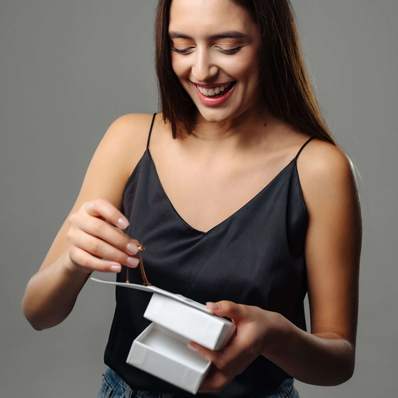 Woman joyfully unboxing the Sunflower Photo Necklace from Brother & Sisters, showcasing personalized jewelry.
