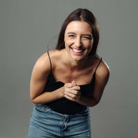 Thumbnail for Smiling woman wearing casual attire, showcasing joy and positivity with a playful pose.