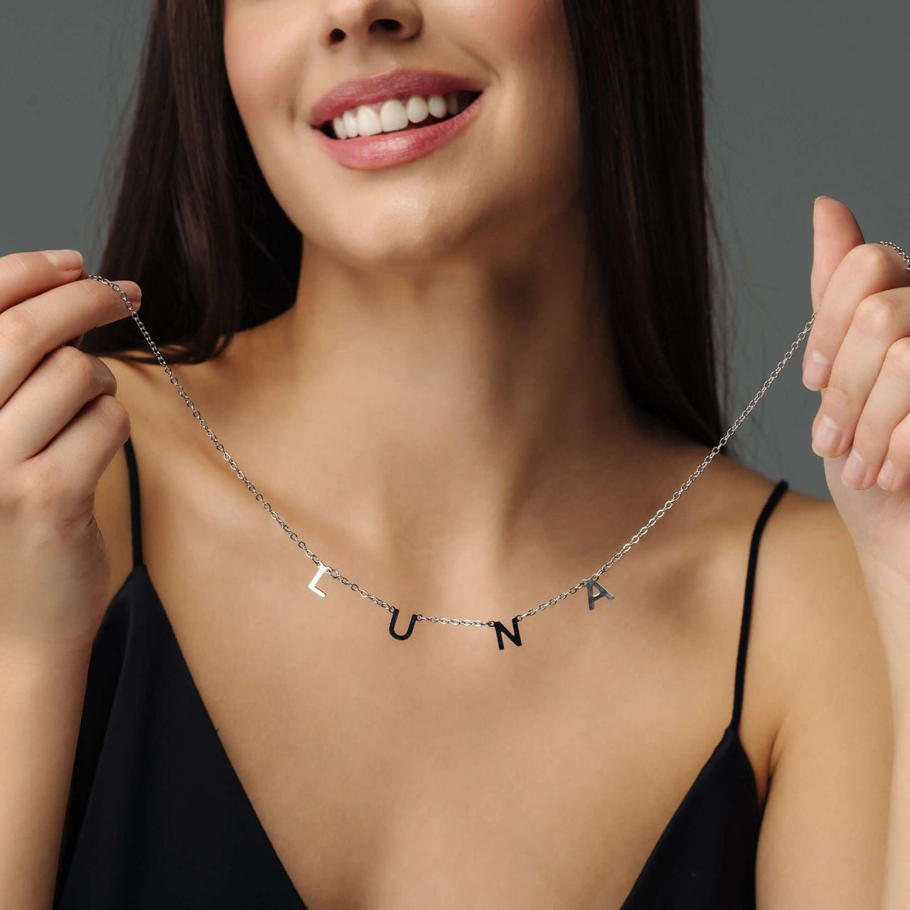 Woman wearing Classic Name Necklace with letters LUNA, showcasing personalized jewelry from Brother & Sisters.