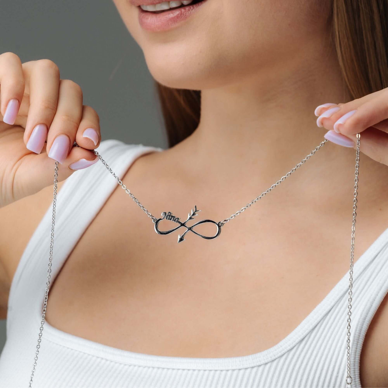 Woman wearing an Arrow Name Necklace by Brother & Sisters, showcasing elegant personalized design with an arrow detail.