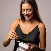 Thumbnail for Happy woman unboxing the Timeless Photo Necklace gift from Brother & Sisters, showcasing its elegance and charm.
