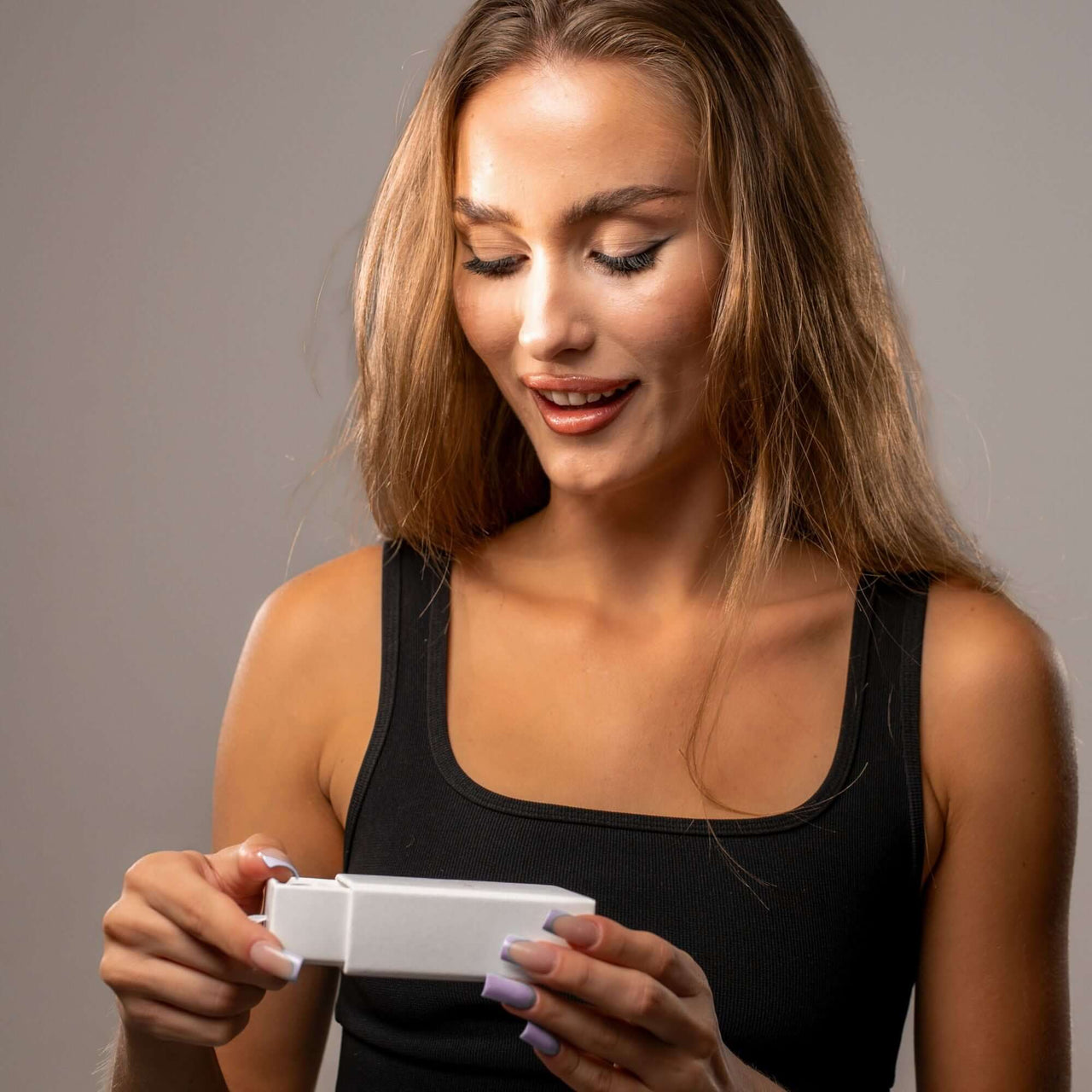 Woman happily unboxing the Love Photo Necklace by Brother & Sisters, showcasing a unique and personalized keepsake.