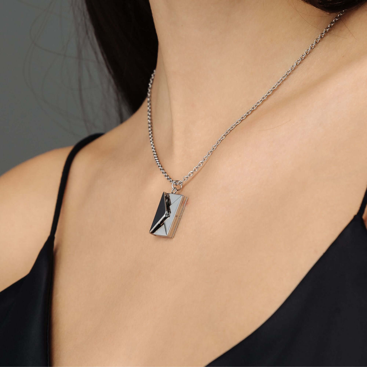Envelope Name Necklace by Brother & Sisters, personalized silver pendant necklace worn elegantly on a woman.