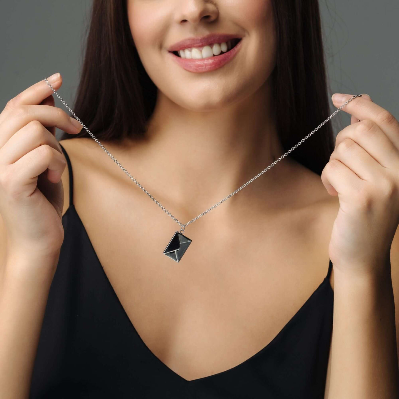 Model showcasing the Envelope Name Necklace by Brother & Sisters, personalized silver jewelry with elegant design.