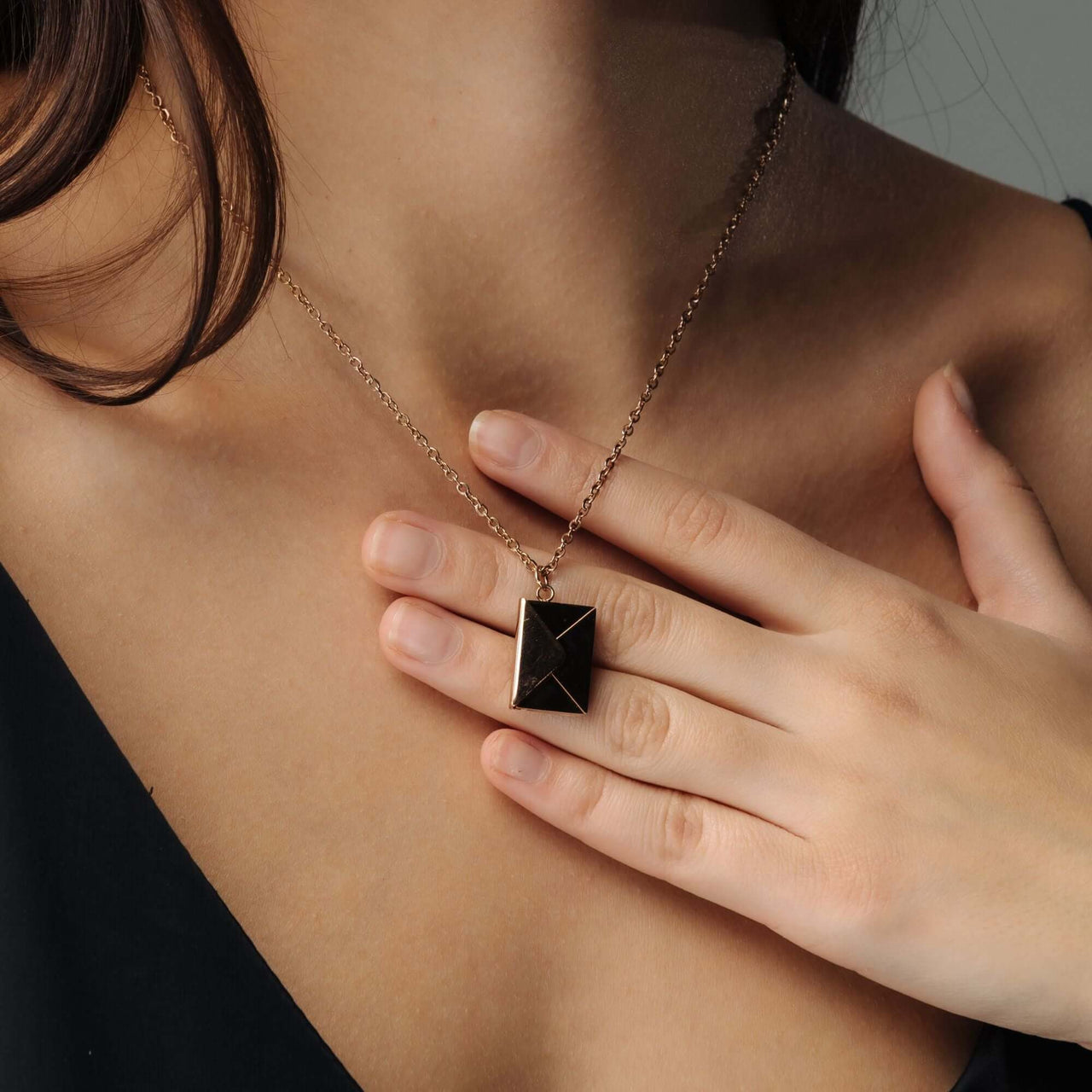 Envelope Name Necklace worn by a woman, featuring an elegant envelope pendant from Brother & Sisters.