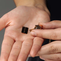 Thumbnail for Envelope Name Necklace by Brother & Sisters held in hand, showcasing personalized design and elegance.