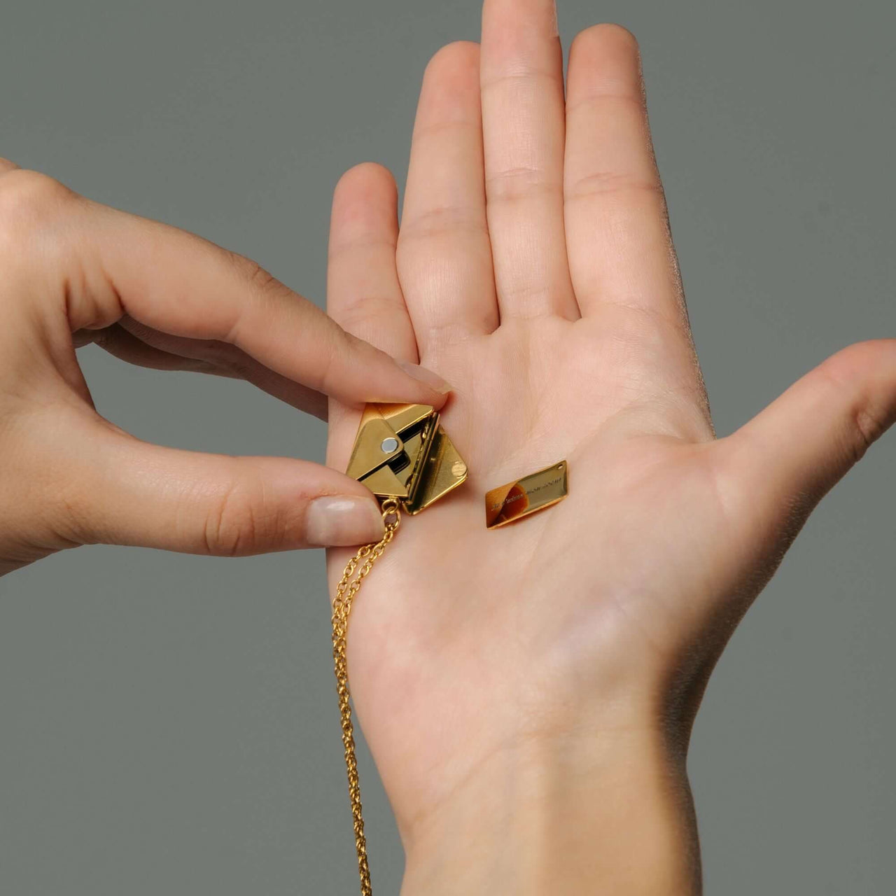 Person holding the Envelope Name Necklace components, showcasing its elegant design by Brother & Sisters.