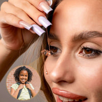 Thumbnail for Close-up of a woman holding the Eye Photo Necklace by Brother & Sisters, showcasing customizable photo projection.
