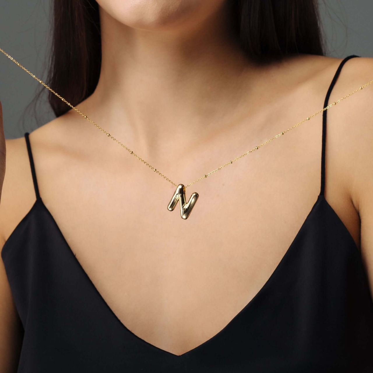 Essential Initial Necklace displayed on a model, featuring a gold 'N' initial, by Brother & Sisters.