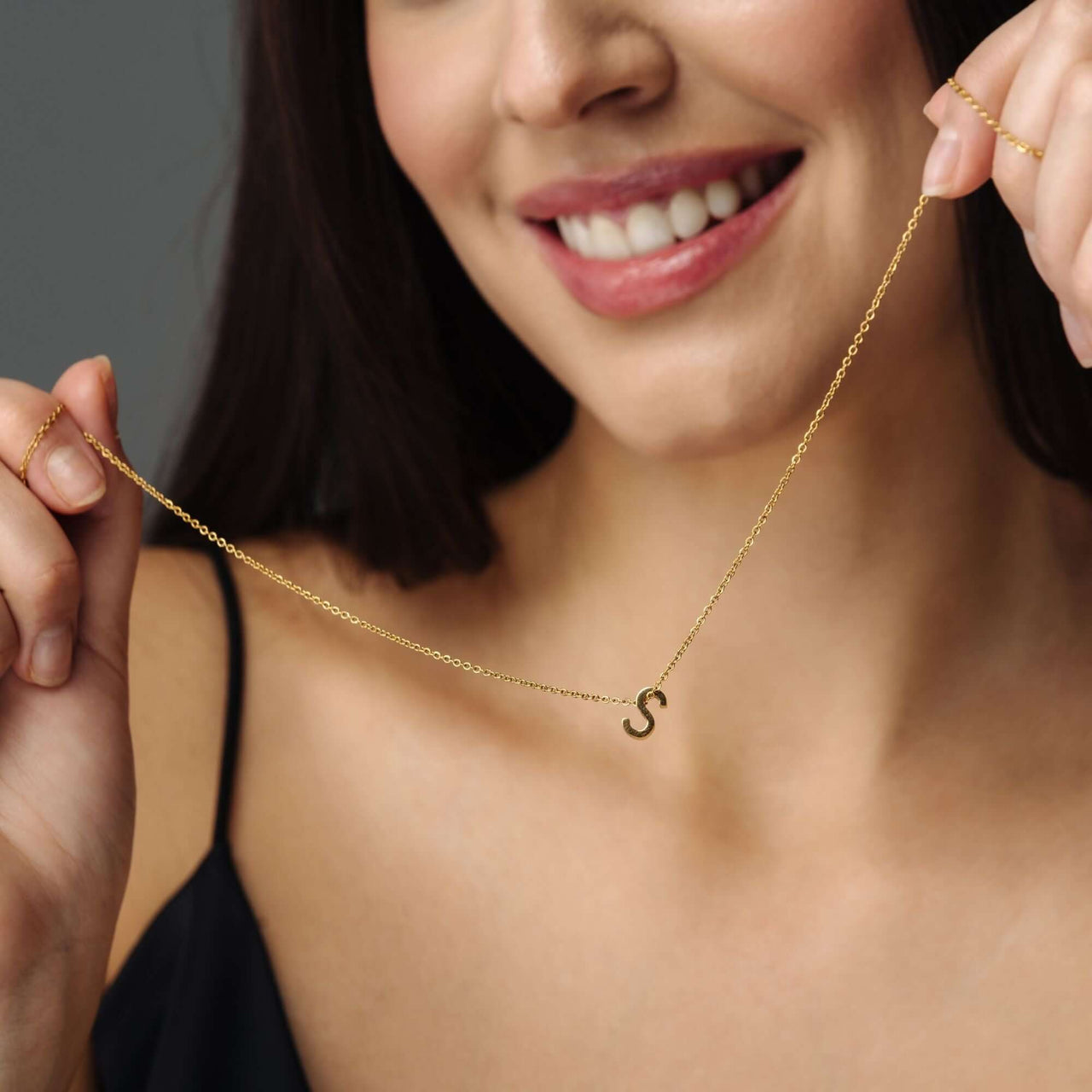 Model showcasing the Iconic Initial Necklace by Brother & Sisters, featuring a gold letter 'S' for personalized elegance.
