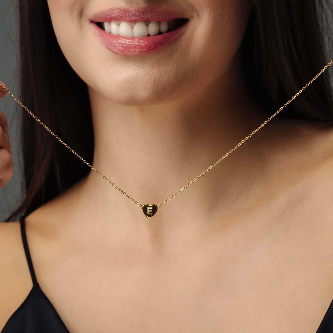 Love Initial Necklace worn by a woman featuring a gold chain and customizable initial charm from Brother & Sisters.