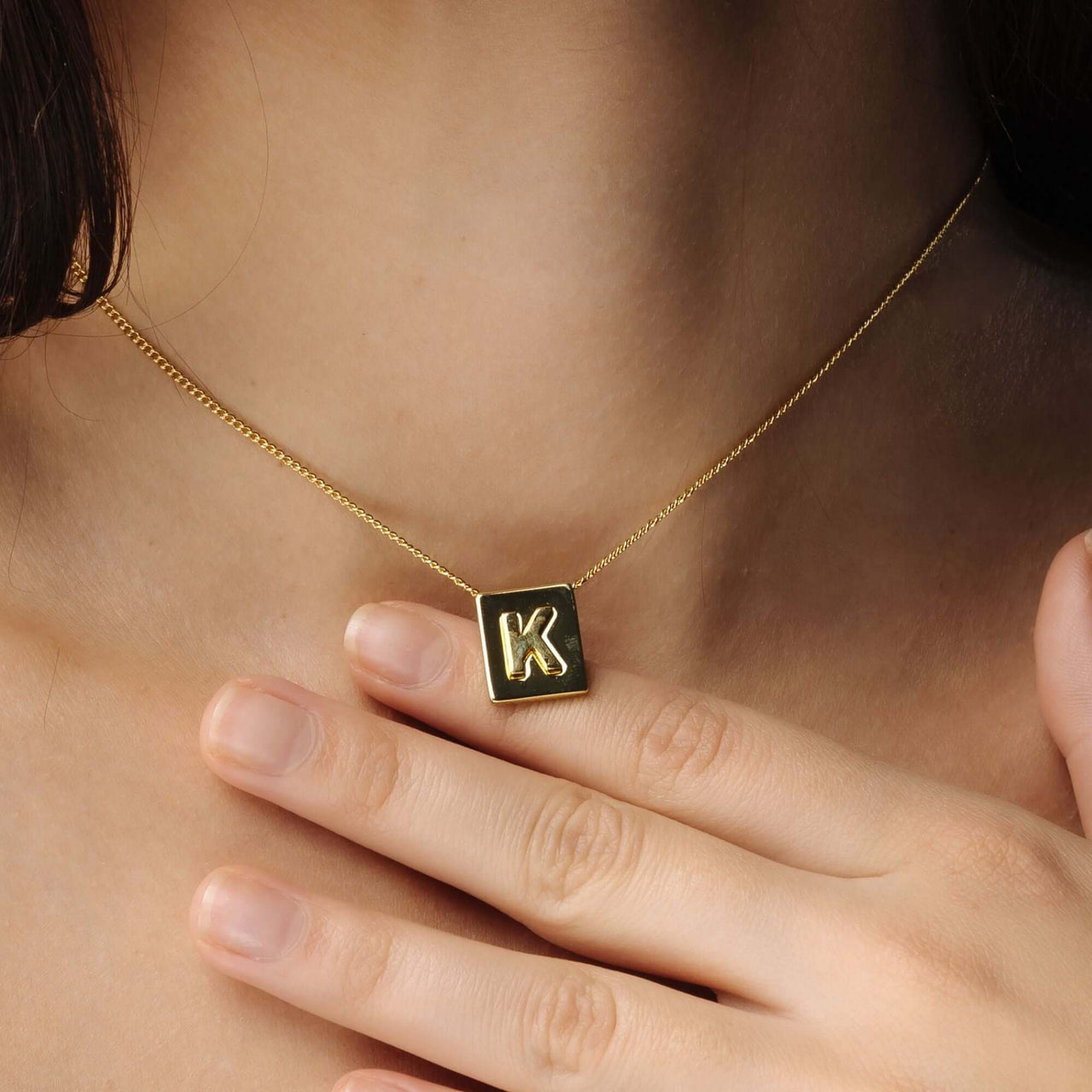 Rectangle Initial Necklace with a gold square pendant featuring the letter K, by Brother & Sisters.