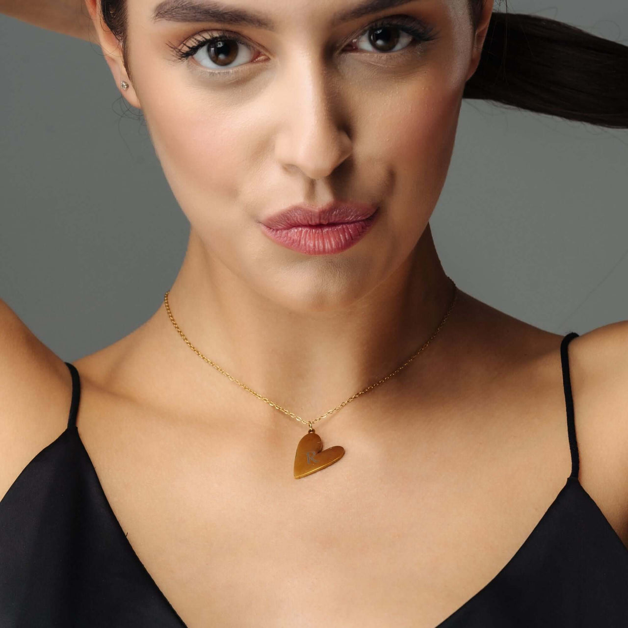 Romantic Initial Necklace worn by a woman, showcasing a gold heart pendant for timeless elegance by Brother & Sisters.