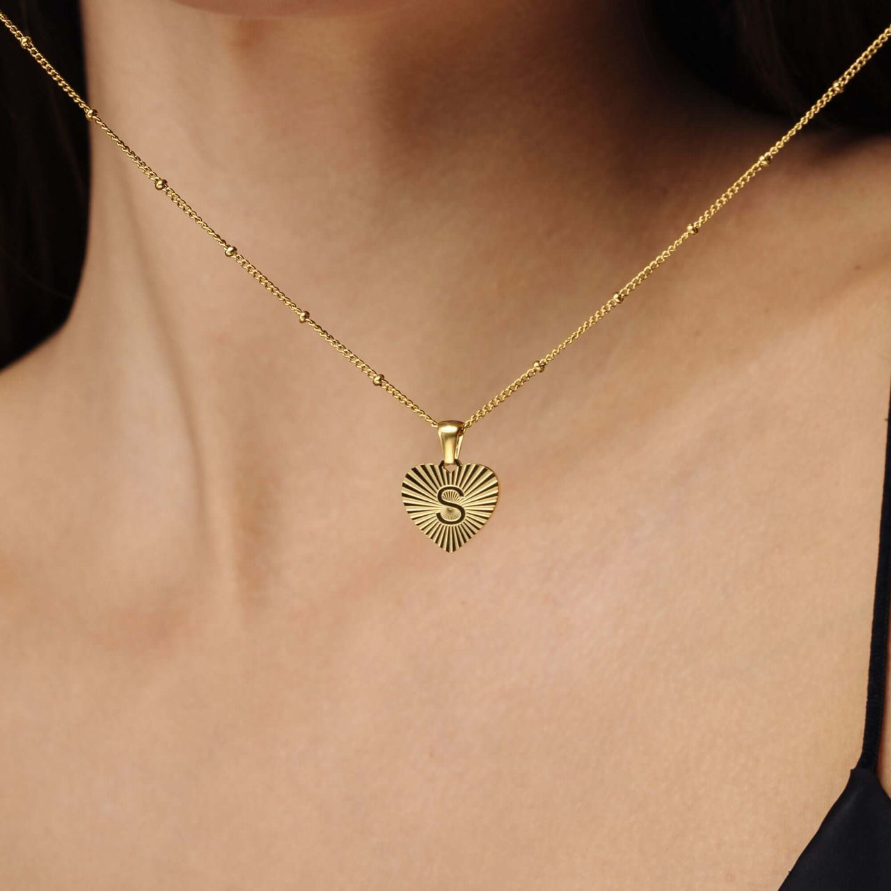 Sentimental Initial Necklace showcased on a woman, featuring a heart-shaped gold pendant with 'S', by Brother & Sisters.