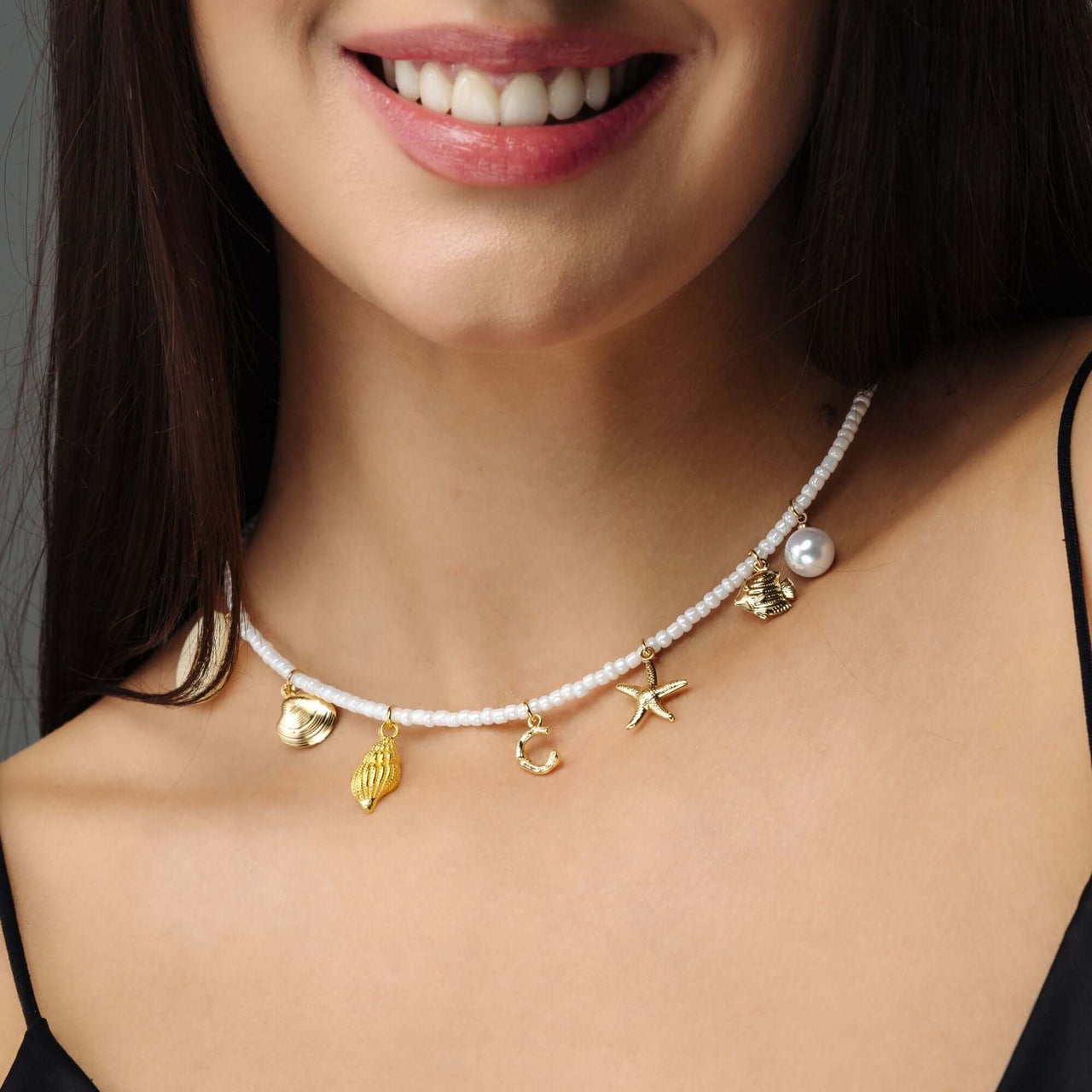 Summer Initial Necklace by Brother & Sisters featuring gold ocean-inspired charms and pearl accents.