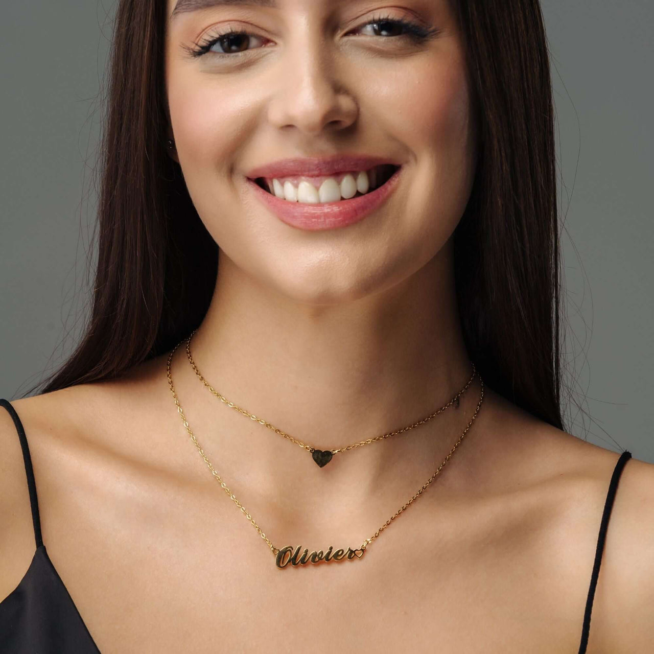 Heart Name Necklace worn by a woman, featuring a custom nameplate and heart charm, by Brother & Sisters.