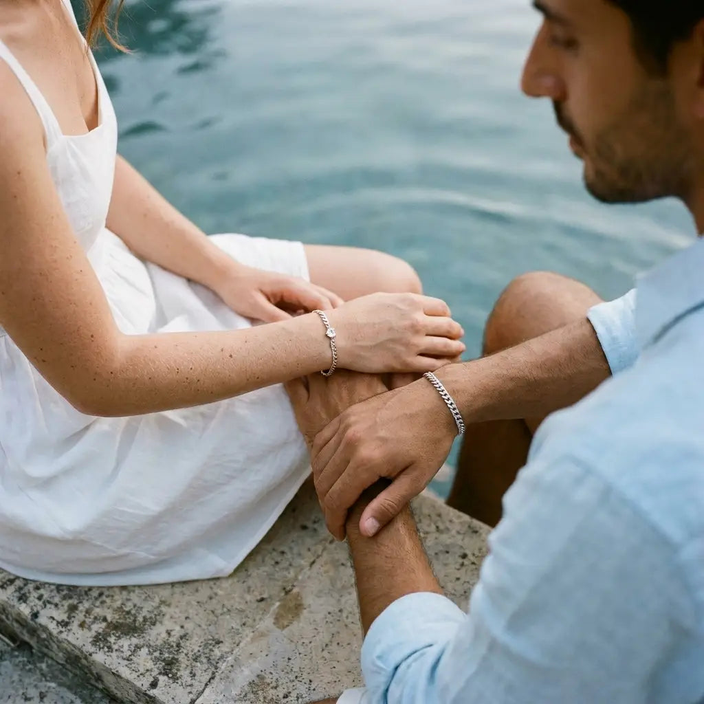 French-Italian couple by Mediterranean villa pool wearing matching silver Heart Bond bracelets