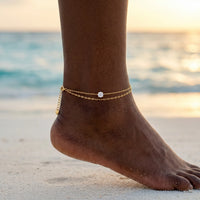 Thumbnail for Amalfi Layered Anklet on Caribbean Black model ankle at Maldives sunset — golden hour beach lifestyle, 2 layered gold chains with CZ, waterproof B&S 316L