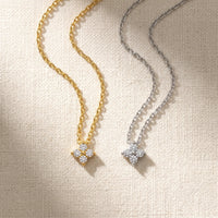 Thumbnail for Crystal Flower necklace gold and silver side-by-side flatlay on cream linen — both finishes available, refined four-leaf zircon flower pendant