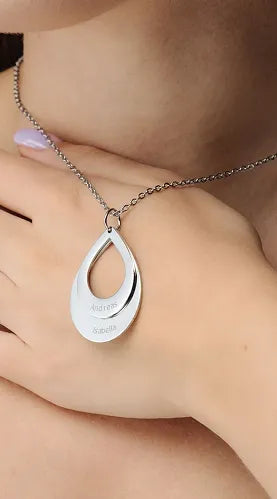 Close-up view of a woman showcasing a sterling silver adjustable projection ring, featuring a subtle floral design and a dark, central memory stone. An embedded image highlights the personalized aspect, showing a joyful couple embracing.