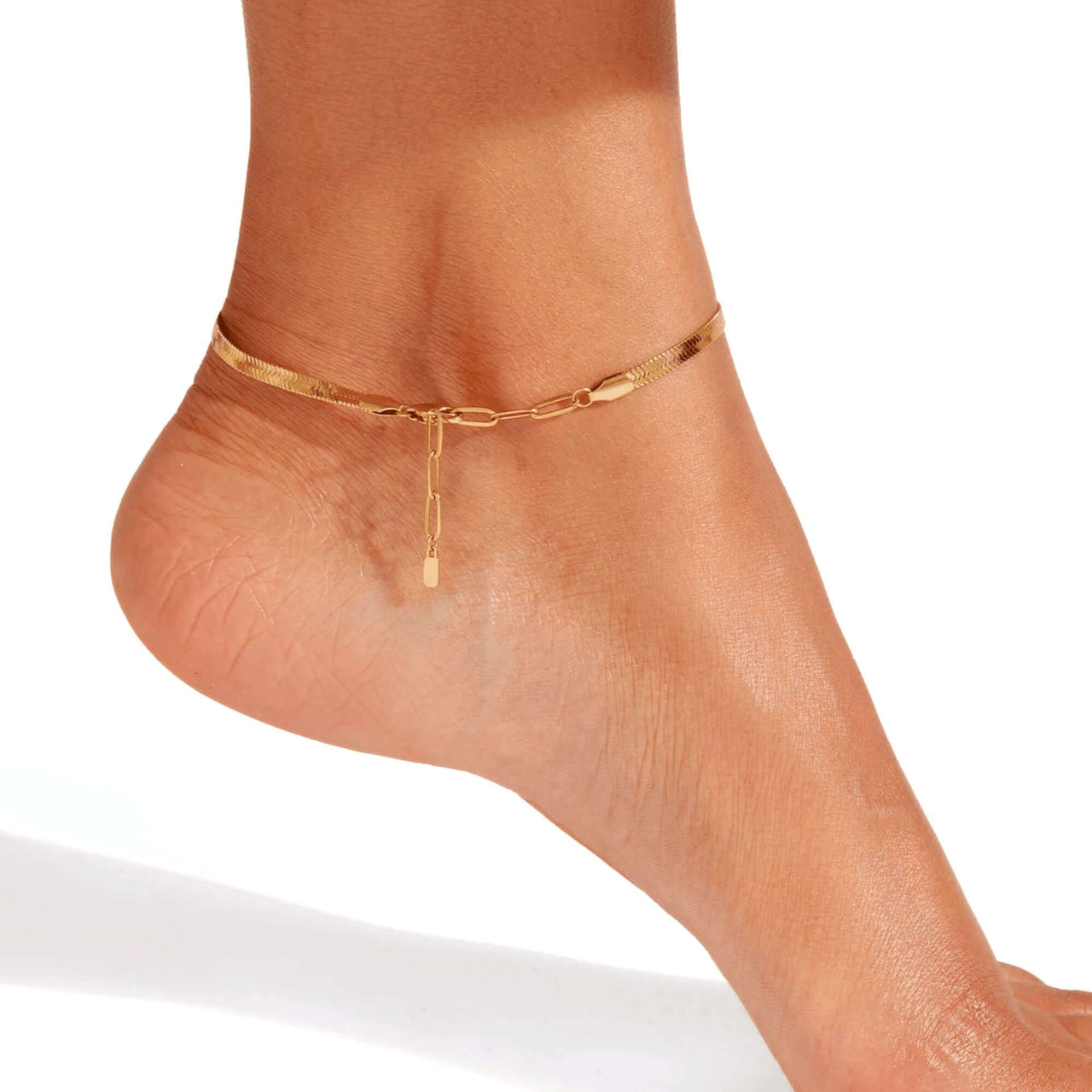 Layla gold anklet profile view on bare ankle — flat snake chain with adjustable paperclip extension visible