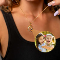 Thumbnail for Lucky Moon Photo Necklace featuring a crescent moon charm projecting a photo of joyful children, by Brother & Sisters.