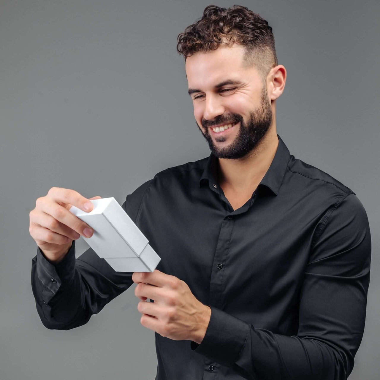 Happy man unboxing the Minimalist Photo Bracelet by Brother & Sisters, showcasing its premium gift presentation.