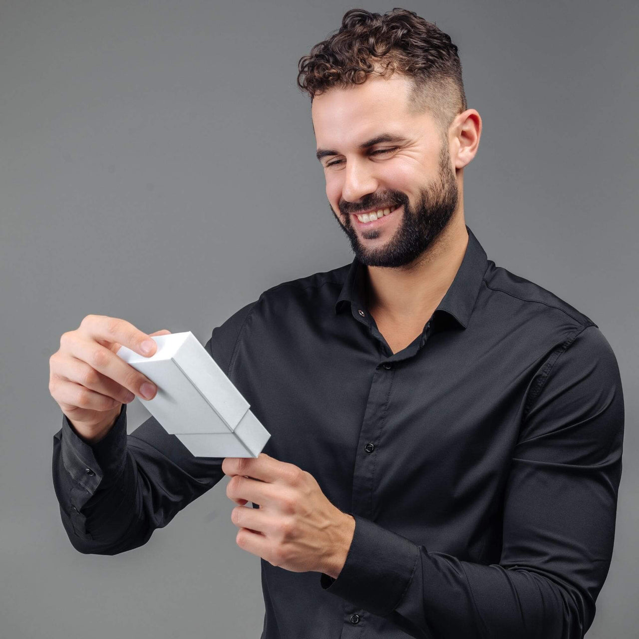 Man Blue Photo Bracelet gift being unwrapped by a smiling man in black shirt, featuring personalized photo pendant.