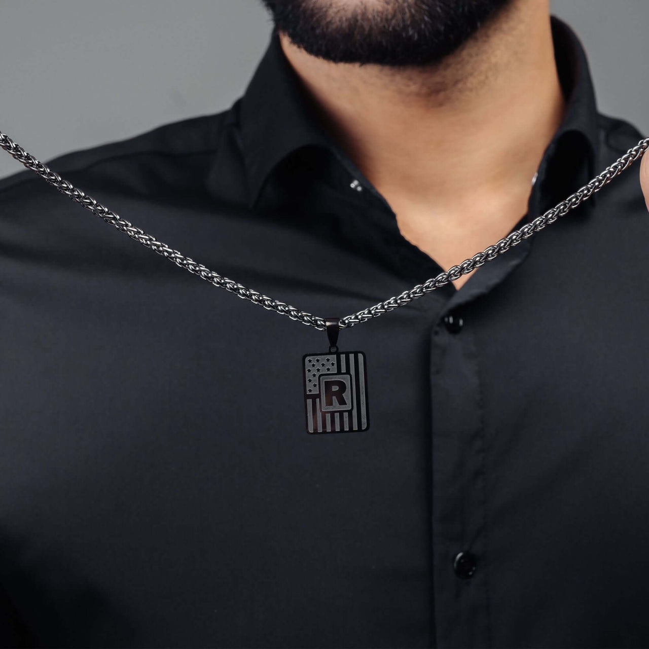 Military Initial Necklace featuring a black letter pendant on a chain, by Brother & Sisters, symbolizing strength.