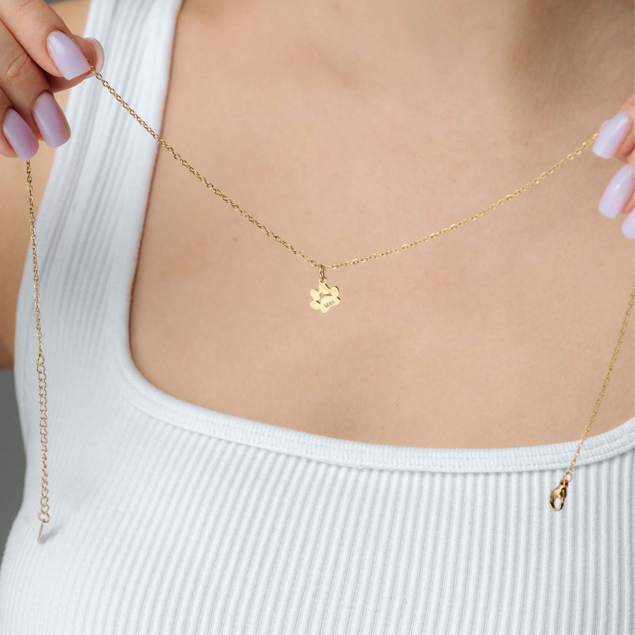 Paw Name Necklace held by a person, showcasing the delicate gold chain and personalized charm, made by Brother & Sisters.