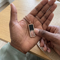 Thumbnail for Thumb warming the rose gold bar pendant: the hidden photo appears under the thumb while the rest stays black | SKU: TPH-BARN-ROSEGOLD