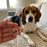 Thumbnail for Customer photo: the rose gold oval necklace with her beagle's photo, her dog in the background | SKU: TPH-OVLN-ROSEGOLD