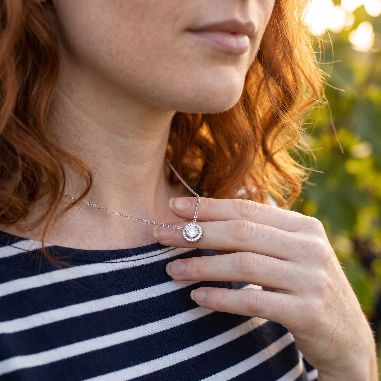 Woman gently touching her silver necklace | SKU: 33136351