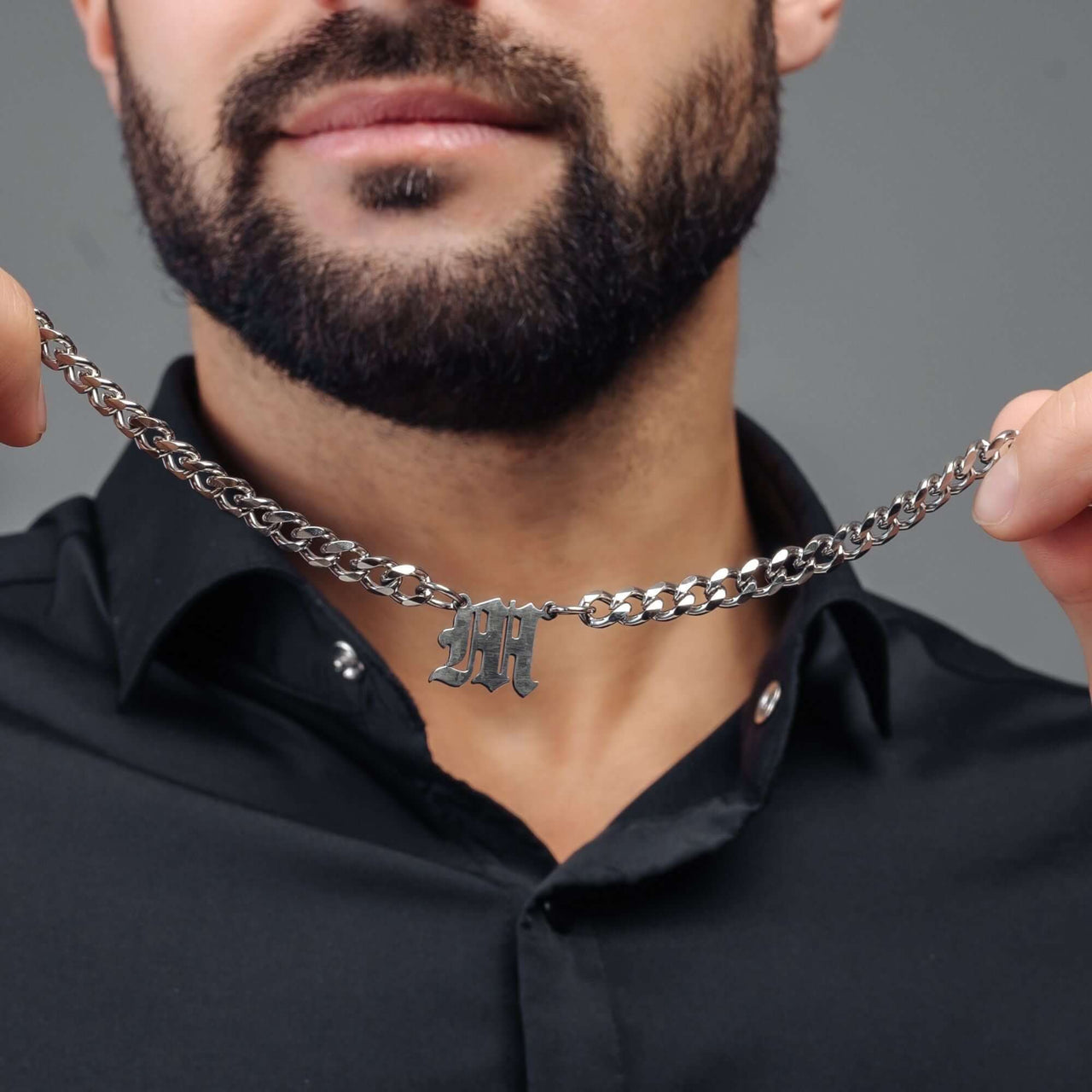 Man showcasing the bold Silver Fire Initial Necklace by Brother & Sisters, featuring a sleek chain and personalized initial.
