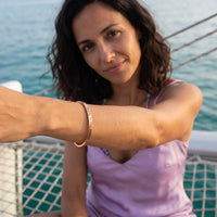 Thumbnail for Travel To Feel Alive bracelet in rose gold worn during a relaxed moment | SKU: ttfa-rg