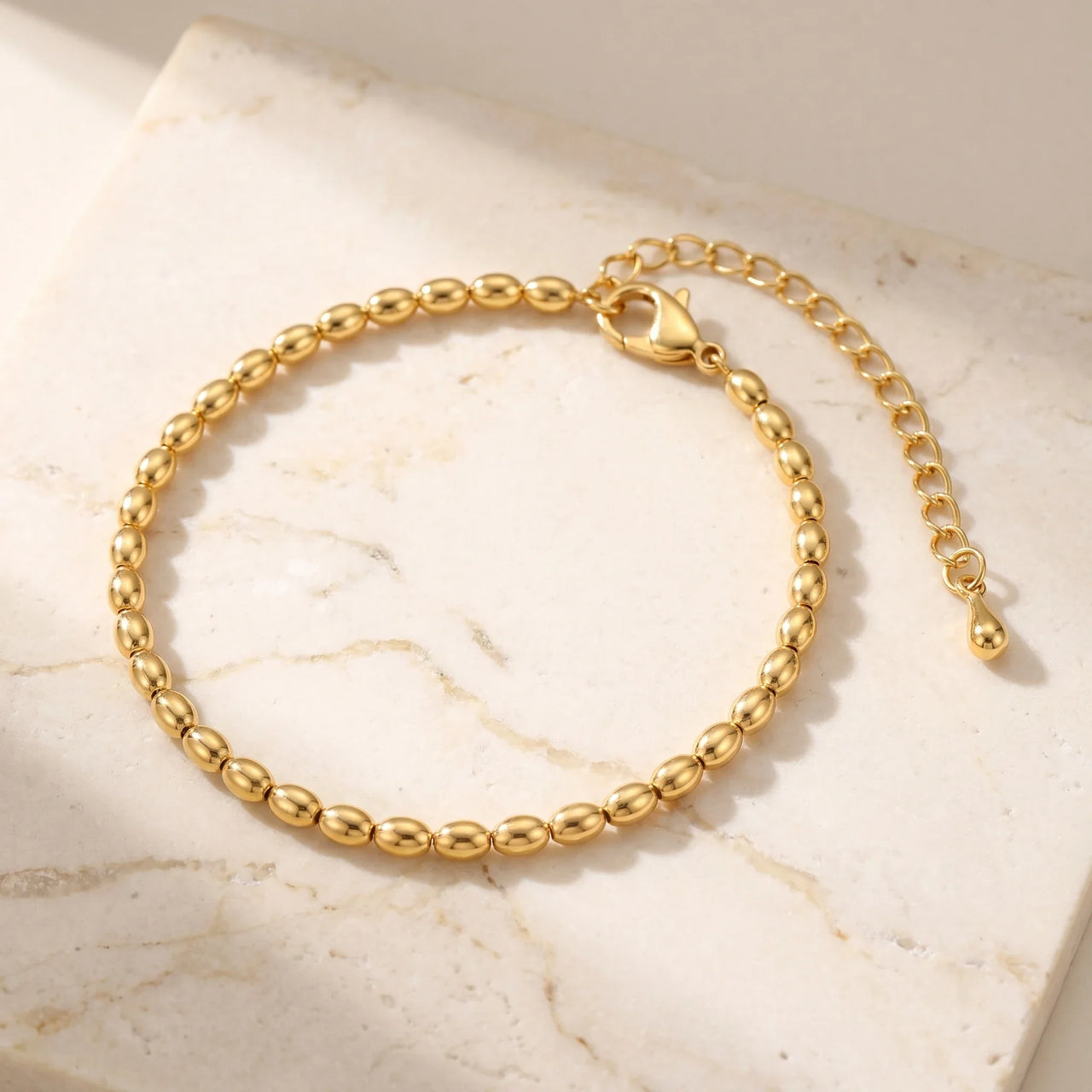 Elegant Oval Bead Anklet by Brother & Sisters features tiny gold beads, handcrafted detail, pure golden light.