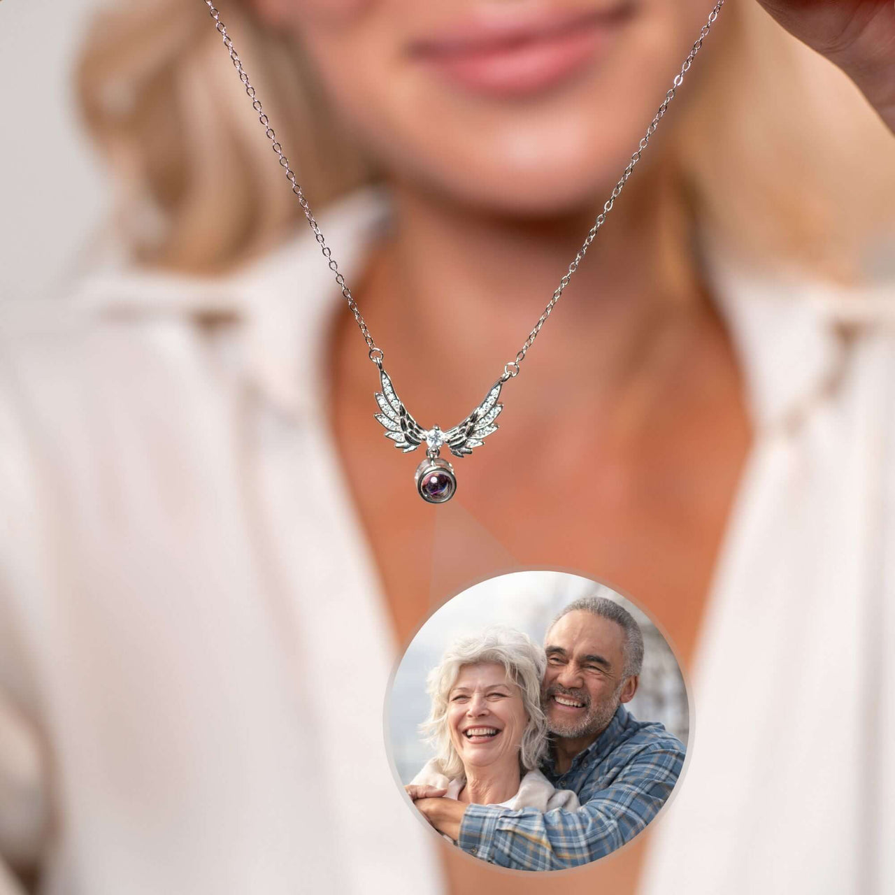 Wings Photo Necklace from Brother & Sisters featuring elegant angel wings and a personalized photo of a couple.